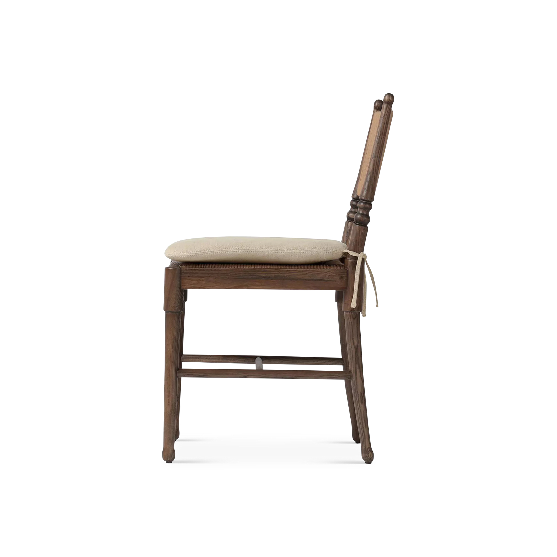 Side view of wooden chair with beige cushion